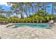 Tranquil pool surrounded by tropical landscaping and a patio at 7064 Baypine Ln, Englewood, FL 34224