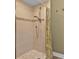 Walk-in shower with textured tile and a handheld shower head at 7064 Baypine Ln, Englewood, FL 34224