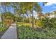 Landscaped yard with a path, palm trees, and greenery at 7064 Baypine Ln, Englewood, FL 34224