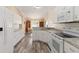 Bright, all-white kitchen with breakfast bar, stainless steel appliances, and hardwood floors at 792 Lehigh Rd, Venice, FL 34293
