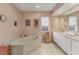 Pink bathroom with double vanity, large soaking tub, and white tile floors at 9131 Berendo Ave, Englewood, FL 34224