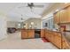 Open kitchen with wood cabinets, black appliances, and an island with granite countertop at 9131 Berendo Ave, Englewood, FL 34224