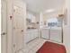 Laundry room with white cabinets, washer and dryer, and red rug at 9131 Berendo Ave, Englewood, FL 34224