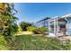 Screened-in pool and patio area surrounded by lush landscaping at 9131 Berendo Ave, Englewood, FL 34224