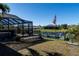 Private backyard with a screened lanai, boat dock, and American flag at 9300 Miami Cir, Port Charlotte, FL 33981