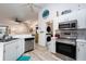 Kitchen featuring white cabinetry, stainless steel appliances, and wood-look flooring at 9300 Miami Cir, Port Charlotte, FL 33981