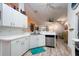 Bright kitchen with white cabinets, stainless steel dishwasher, and open layout at 9300 Miami Cir, Port Charlotte, FL 33981