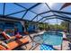 Inviting pool area with a covered patio, outdoor bar, and lush landscaping at 9300 Miami Cir, Port Charlotte, FL 33981