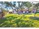 House exterior with large oak trees and waterfront access at 99 W Riverview Ave, Englewood, FL 34223