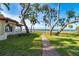 Waterfront yard with a walkway and oak trees at 99 W Riverview Ave, Englewood, FL 34223