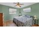 Second bedroom with wood floors, ceiling fan, and floral bedding at 10191 Rafferty Ave, Englewood, FL 34224