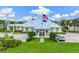 Community center with a green roof, landscaping, and American flag at 10300 Coral Landings Ct # 91, Placida, FL 33946