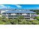 Tan building with metal roof, screened balconies, and lush landscaping at 10300 Coral Landings Ct # 91, Placida, FL 33946