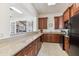 Well-equipped kitchen with granite countertops, wooden cabinets, and modern appliances overlooking a living area at 10300 Coral Landings Ct # 91, Placida, FL 33946