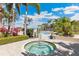 Relaxing community hot tub surrounded by tropical landscaping and a beautiful pool on a sunny day at 10300 Coral Landings Ct # 91, Placida, FL 33946