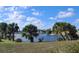 Serene lake view with lush landscaping and palm trees at 13489 Bennett Dr, Port Charlotte, FL 33981