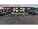 Exterior view of condo building at dusk with parking spaces in front at 25100 Sandhill Blvd # B-103, Punta Gorda, FL 33983