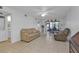Living room with beige couches, tiled floors, and access to kitchen and dining at 25100 Sandhill Blvd # B-103, Punta Gorda, FL 33983