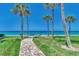 Brick pathway leads to the beach with palm trees along the way at 2950 N Beach Rd # A315, Englewood, FL 34223