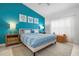 Bright bedroom with teal accent wall and king-size bed at 412 Sunset Lake Blvd # 206, Venice, FL 34292