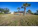 Large, grassy backyard with palm trees and covered patio at 4658 Arlington Dr, Placida, FL 33946