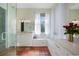 Bright bathroom featuring dual vanities, glass shower, and tiled floors at 4658 Arlington Dr, Placida, FL 33946
