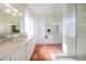 Bright bathroom with dual vanities, a glass-enclosed shower, and tiled flooring at 4658 Arlington Dr, Placida, FL 33946