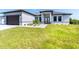 New construction home with a modern facade, two-car garage, and landscaped lawn at 6191 Kambach St, Port Charlotte, FL 33981