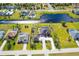 An aerial view of the property and the surrounding neighborhood, featuring lush green lawns and a tranquil canal at 646 Boundary Blvd, Rotonda West, FL 33947