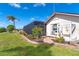 Backyard with screened-in patio, lush landscaping, and a palm tree at 646 Boundary Blvd, Rotonda West, FL 33947
