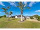 Large backyard with palm trees, lush green grass, and a gravel border at 646 Boundary Blvd, Rotonda West, FL 33947