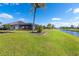 Large grassy backyard, canal, palm trees, and pool area at 646 Boundary Blvd, Rotonda West, FL 33947
