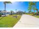 Well-maintained home with a long concrete driveway, lush green lawn, and mature tropical landscaping at 646 Boundary Blvd, Rotonda West, FL 33947
