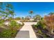 Path leading through a well-maintained yard with a variety of plants and palm trees at 646 Boundary Blvd, Rotonda West, FL 33947