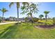 Tropical landscaping surrounds this home with palm trees and lush green lawn at 646 Boundary Blvd, Rotonda West, FL 33947