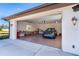 View of a garage with an electric car parked inside, open garage door, and driveway at 646 Boundary Blvd, Rotonda West, FL 33947