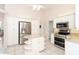 Kitchen featuring white cabinets, an island with shelving, and stainless steel appliances at 646 Boundary Blvd, Rotonda West, FL 33947