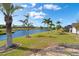 Tranquil waterfront property with palm trees, lush grass, and a serene canal view at 646 Boundary Blvd, Rotonda West, FL 33947