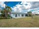 Home with grassy backyard and patio at 691 Linden Dr, Englewood, FL 34223