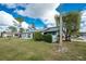 Light blue house with grey roof, well-manicured lawn, and partial view of neighboring houses at 691 Linden Dr, Englewood, FL 34223