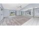 Bright living room with vaulted ceiling, grey carpet, and mirrored wall at 691 Linden Dr, Englewood, FL 34223