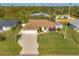 Single-Gathering home with a large front yard and a two-car garage, seen from an aerial perspective at 9266 Carnation Ave, Englewood, FL 34224