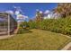 Landscaped backyard featuring a large grassy area and hedge at 9266 Carnation Ave, Englewood, FL 34224