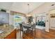 Bright dining area with a round table and chairs, next to the kitchen, featuring hardwood floors at 9266 Carnation Ave, Englewood, FL 34224