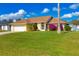 House exterior with green lawn, palm tree, and attached garage at 9266 Carnation Ave, Englewood, FL 34224