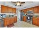 Modern kitchen with wood cabinets, granite counters, and stainless steel appliances at 9266 Carnation Ave, Englewood, FL 34224
