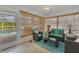Bright sunroom with teal seating, wood flooring, and pool view at 9266 Carnation Ave, Englewood, FL 34224