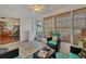 Bright sunroom with tiled floor, wicker furniture, and view into kitchen at 9266 Carnation Ave, Englewood, FL 34224