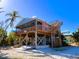 Elevated beach house with decks, screened porch, and stairs to a rooftop terrace at 9526 Jolly Roger Trl, Placida, FL 33946