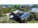 Coastal home with a rooftop deck and stairs, surrounded by tropical vegetation offering serene views at 9526 Jolly Roger Trl, Placida, FL 33946